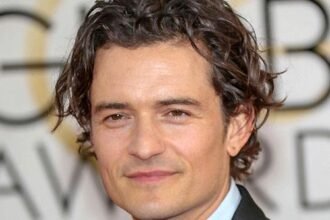 Orlando Bloom looking directly at the camera in a stylish outfit