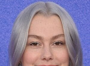 Phoebe Bridgers smiling at a red carpet event.