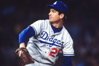 Former MLB pitcher Tommy John smiling during a baseball event