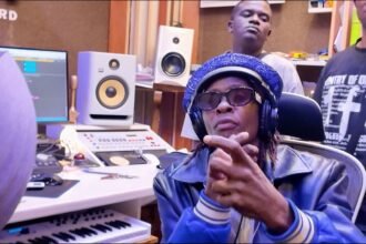 Jose Chameleone performing in front of a microphone in the studio with Jeff Kiwa.