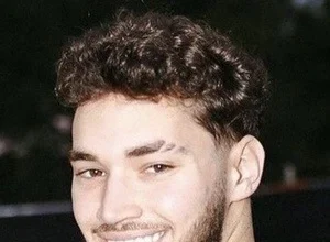 Adin Ross sitting in front of a computer setup during a live video stream.
