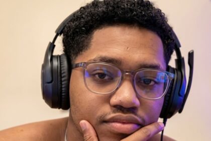 RICHLEV sitting in front of a camera, smiling while reacting to a meme video