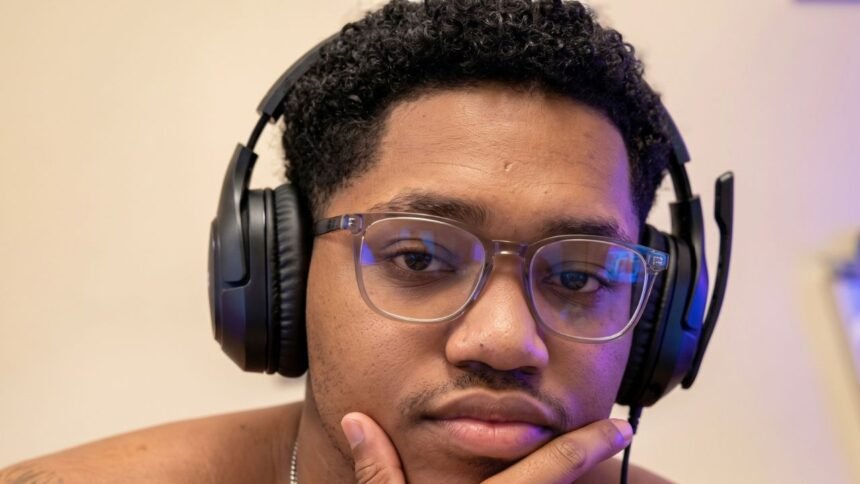 RICHLEV sitting in front of a camera, smiling while reacting to a meme video
