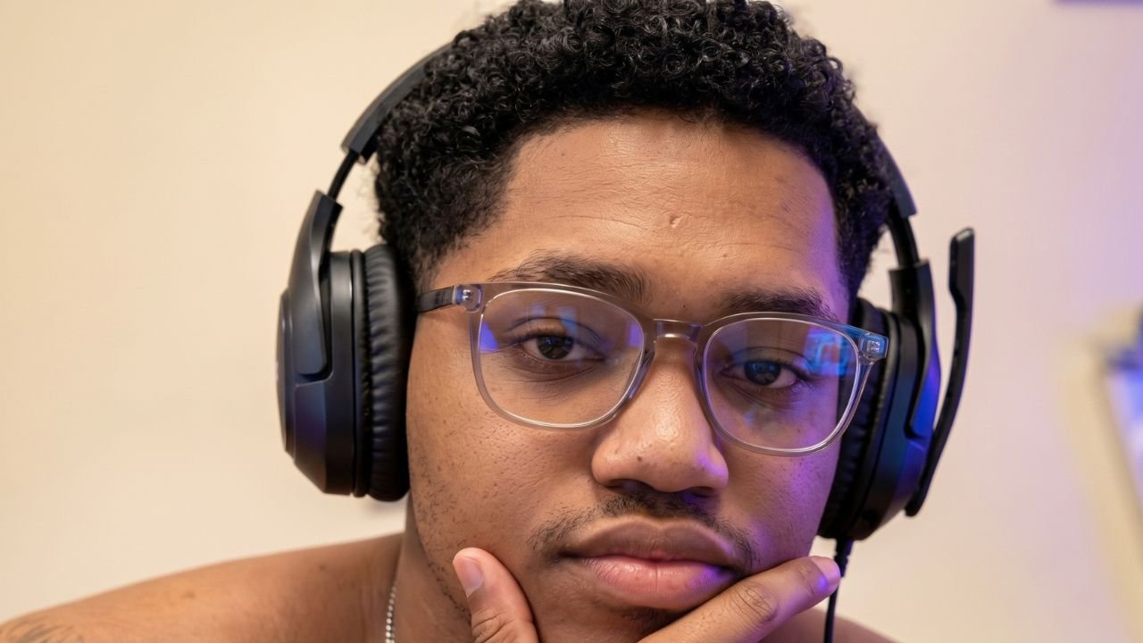 RICHLEV sitting in front of a camera, smiling while reacting to a meme video