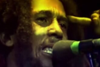 Bob Marley, the Jamaican reggae singer, playing guitar and singing on stage during a live concert in the 1970s