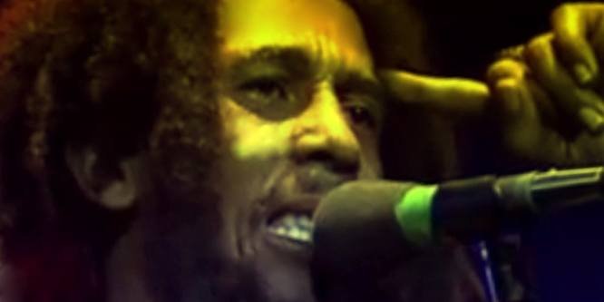 Bob Marley, the Jamaican reggae singer, playing guitar and singing on stage during a live concert in the 1970s