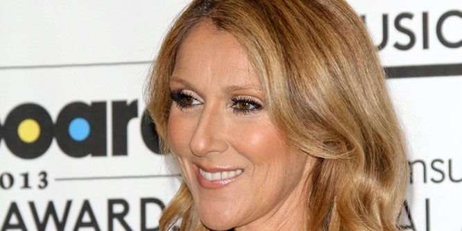 Céline Dion singing on stage into a microphone