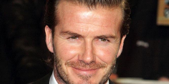 David Beckham smiling while wearing a suit at a public appearance