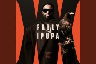 Fally Ipupa singing on stage during a performance of his 2026 single Delirium, with bright stage lighting and a crowd in the background.