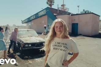 Freya Skye sings in a colorful set with neon lights, wearing a bold outfit while the camera captures close‑up shots of her expressive performance in the "bad taste" music video.