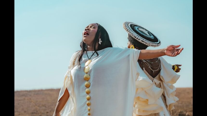 Nontokozo Mkhize and Zawadi Yamungu standing on a hill in the Drakensberg mountains, singing together for the music video of the song "Glory".