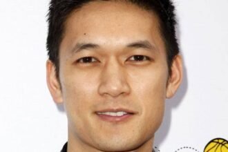 Harry Shum Jr. standing and smiling at a public event.