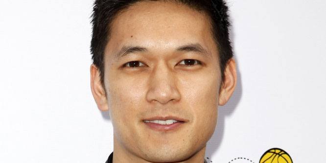 Harry Shum Jr. standing and smiling at a public event.
