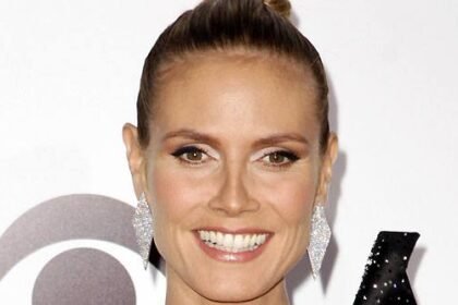 Heidi Klum smiling on a red carpet event.