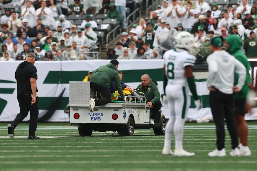 Green Bay Packers receiver Jayden Reed receiving medical attention on the field.