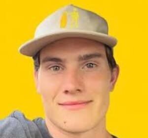 Portrait of Jesse Moncur, a young TikTok star, wearing a casual shirt and smiling while holding a phone