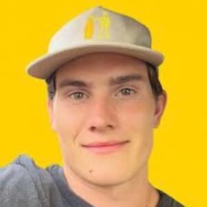 Portrait of Jesse Moncur, a young TikTok star, wearing a casual shirt and smiling while holding a phone