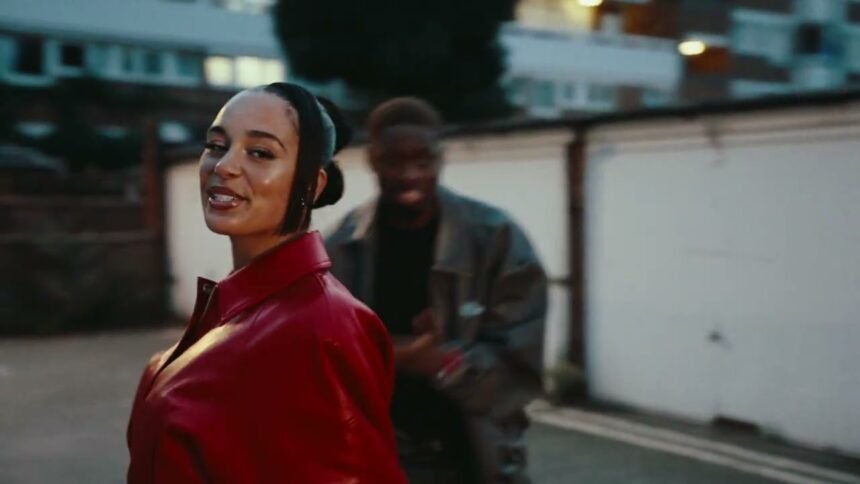 Tiakola and Jorja Smith on stage singing together, with bright lights behind them while performing Jet Lag.