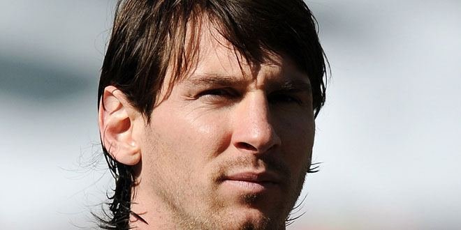 Lionel Messi wearing Inter Miami jersey, standing on the field with a soccer ball.