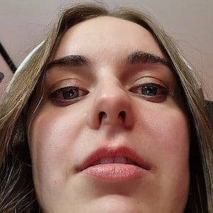 Loserfruit smiling on stage with a gaming backdrop, wearing a casual hoodie and headset.