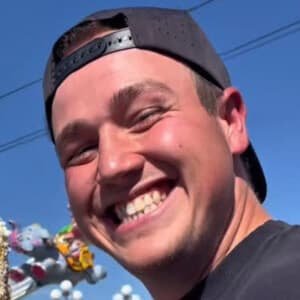 Luke Hoskins, known as TikTok star datrashmaaan, holding lettuce during a break while wearing his garbage truck driver uniform.