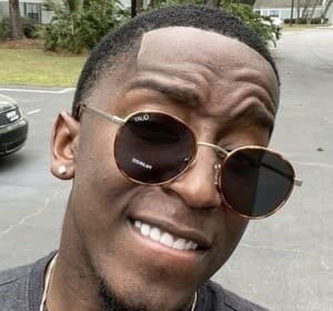 Markell Washington dancing in a bright studio, wearing a casual outfit, captured during a TikTok video.