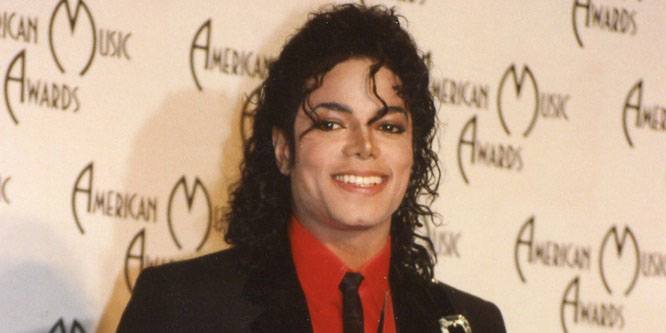 Michael Jackson in a glittering outfit performing his hit song on a large concert stage with bright lights