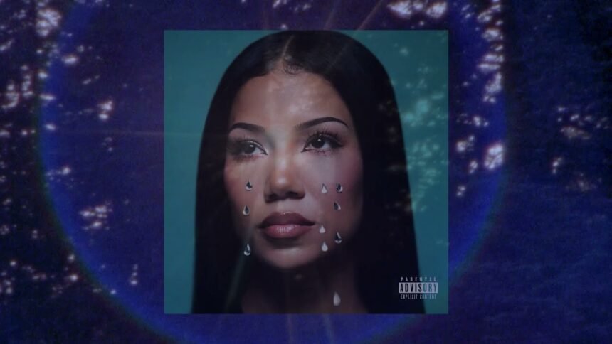 Jhené Aiko singing into a microphone under soft stage lights