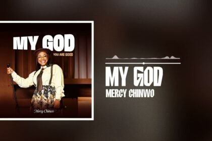 Mercy Chinwo singing the gospel song My God on stage with a microphone