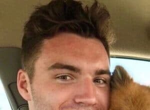 Nick Gallais smiling while holding his cat Bob during a TikTok video shoot