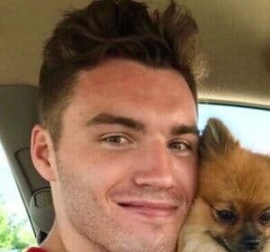 Nick Gallais smiling while holding his cat Bob during a TikTok video shoot