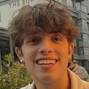 Portrait of Nicolas Sturniolo, a young male TikTok influencer with a bright smile, wearing a casual shirt, standing against a plain background.