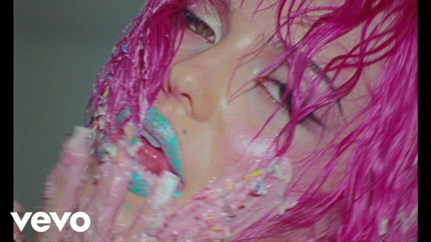 ADÉLA wearing a red corset and dramatic makeup in the 'Nicole Kidman' music video directed by Hannah Lux Davis