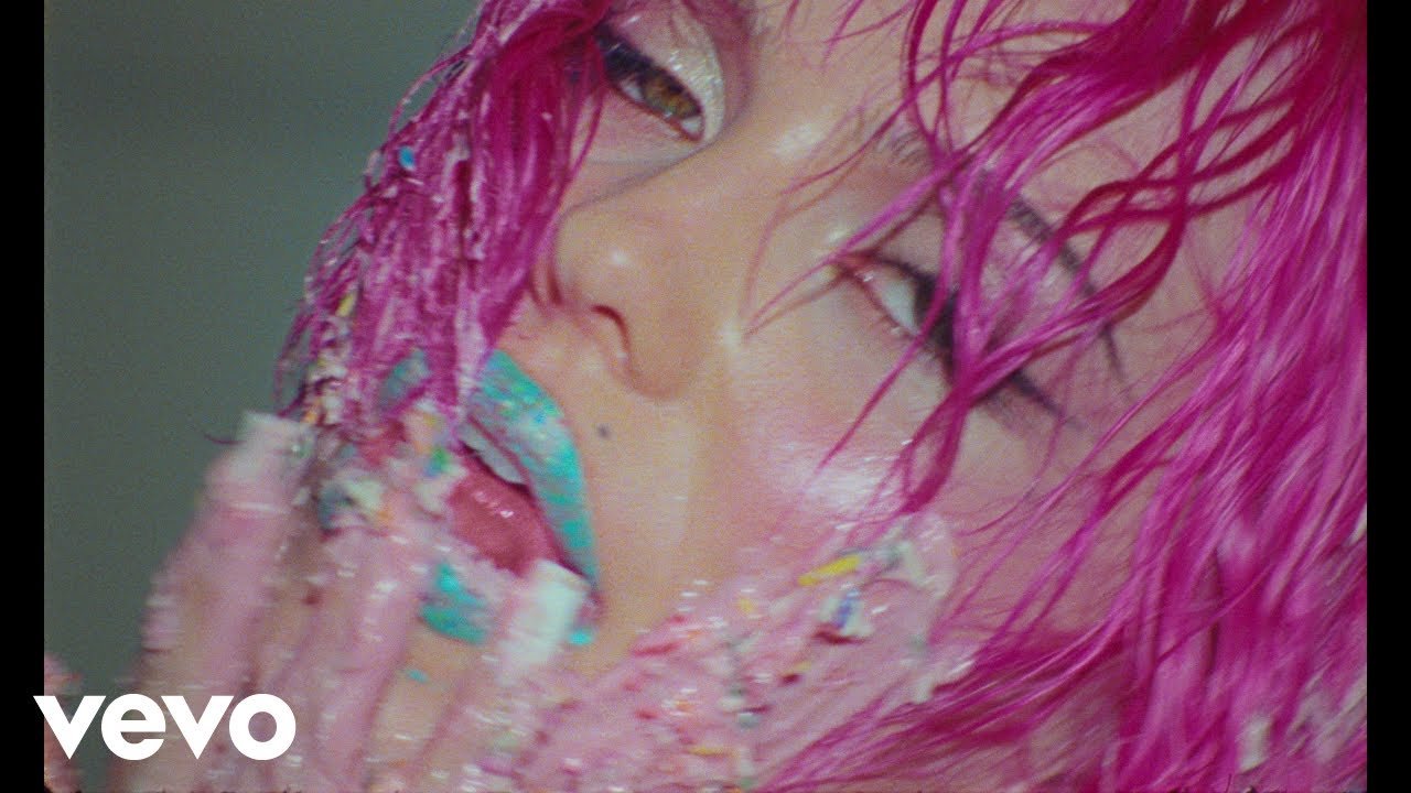 ADÉLA wearing a red corset and dramatic makeup in the 'Nicole Kidman' music video directed by Hannah Lux Davis