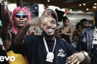 Tommy Lee Sparta and Skeng standing together on a colorful set, wearing street style clothing, performing the song "Protocol 3"