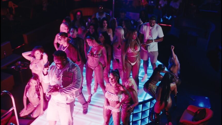 Screenshot from the official music video 'Rain' showing Tee Grizzley, Skilla Baby and Ashanti standing under street lights in rain.