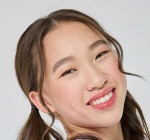 Teen actress Reagan To smiling on stage in a ballroom dance costume during a 2024 competition