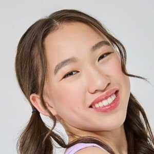 Teen actress Reagan To smiling on stage in a ballroom dance costume during a 2024 competition