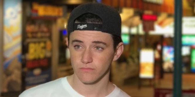 Kyle Godfrey, known as Stromedy, a Canadian YouTube star, smiling in front of his channel logo