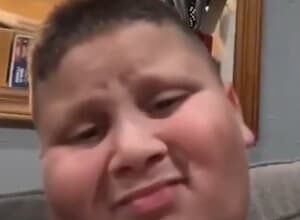 The Rizzler smiling with his iconic "rizz" facial expression while filming a TikTok video