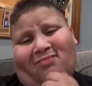 The Rizzler smiling with his iconic "rizz" facial expression while filming a TikTok video