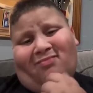 The Rizzler smiling with his iconic "rizz" facial expression while filming a TikTok video