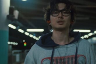 Fujii Kaze performing in the official "You" music video with bright lighting and dancers on set