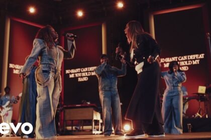 Tasha Cobbs Leonard and Le'Andria Johnson singing together on stage during a live recording