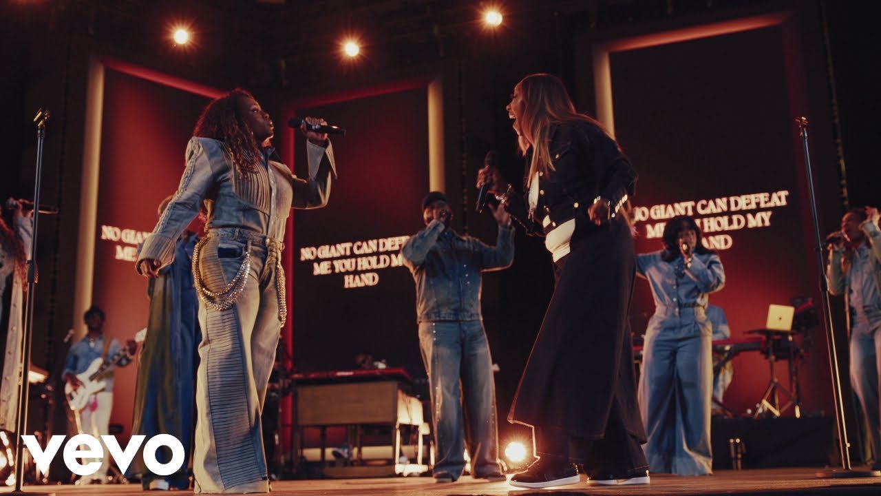 Tasha Cobbs Leonard and Le'Andria Johnson singing together on stage during a live recording
