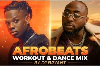 DJ Bryant performing a live set of the Afrobeats Workout & Dance Mix, surrounded by colorful lights and a crowd exercising
