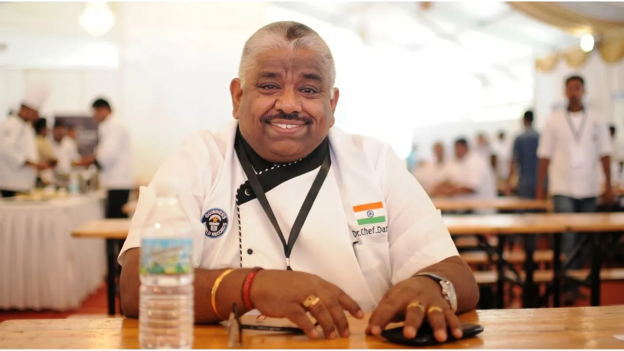 Chef Damodharan smiling while judging contestants on the Tamil TV show Cooku with Comali
