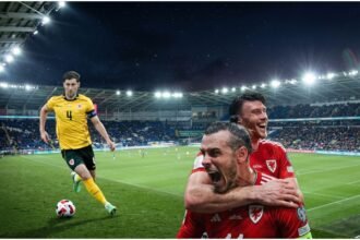Wales vs Norway UEFA Nations League match in Cardiff, showing both teams fighting for the ball under stadium lights.