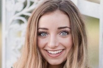 Brooklyn McKnight smiling while filming a family vlog with her twin sister Bailey