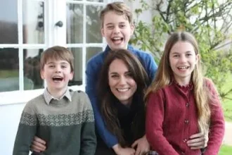 Prince William, Princess Kate, Prince George, Princess Charlotte, and Prince Louis standing together in a green landscape after the Three Peaks Challenge, wearing matching jeans and sneakers.